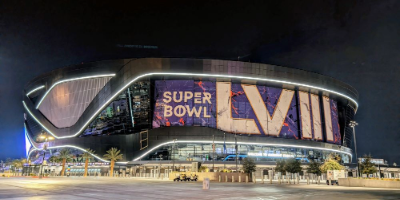 Exterior shot of a football stadium in Las Vegas with an enormous sign on it reading &quot;Super Bowl LVIII&quot;