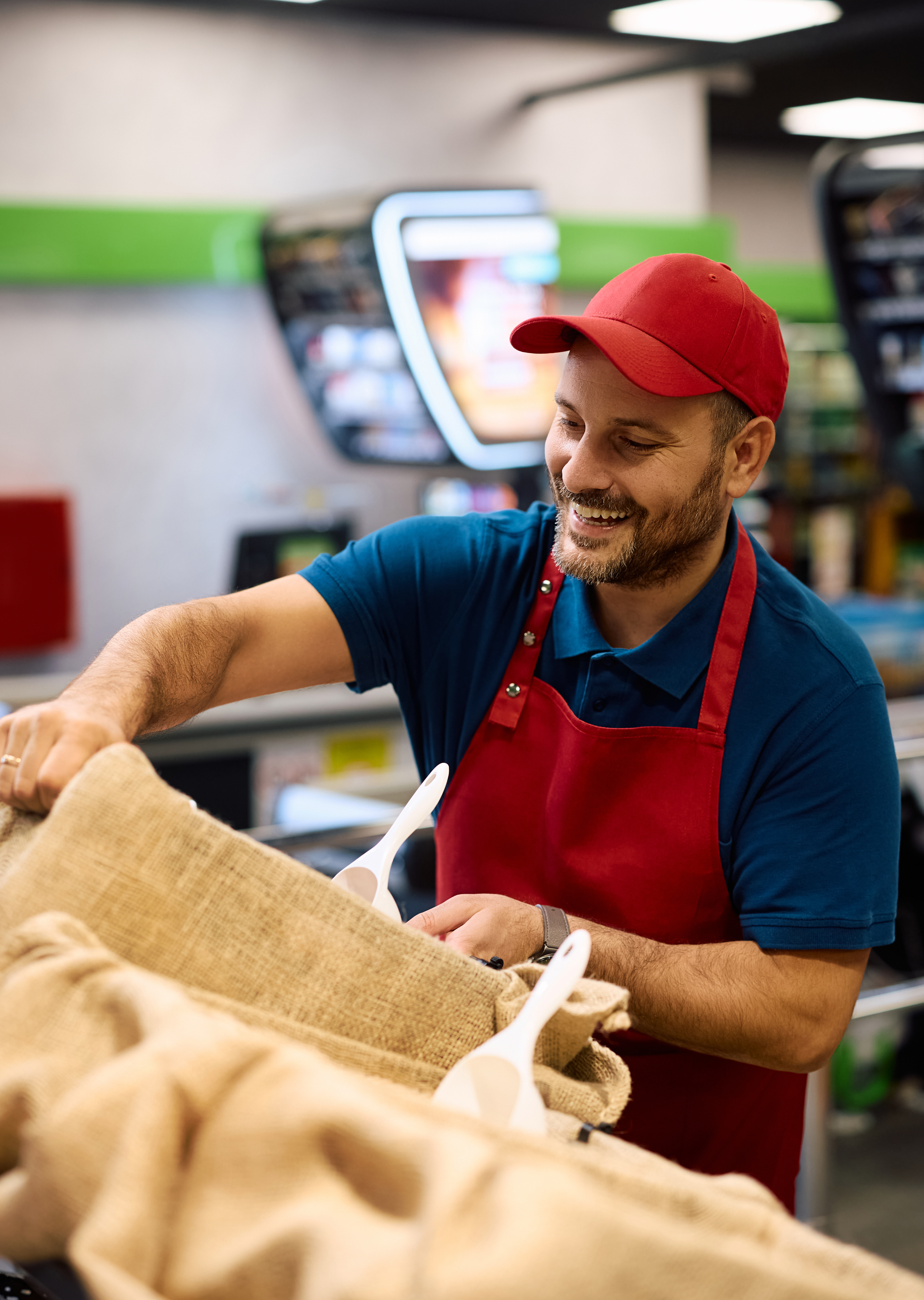A man in a red hat and red apron working 