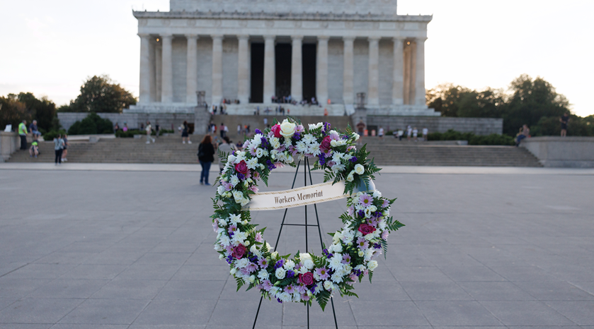 A wreath with the words "Workers Memorial" in front of the Lincoln Memorial in Washington, D.C.