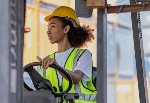 Woman wearing a yellow vest and construction helmet