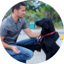 A man trains a dog using a treat
