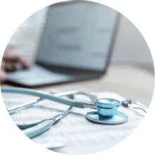 A stethoscope on papers next to a computer