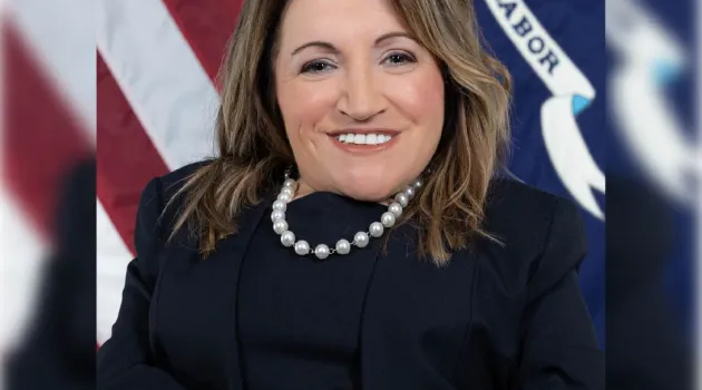 Professional headshot of Julie Hocker in front of the Labor Department flag