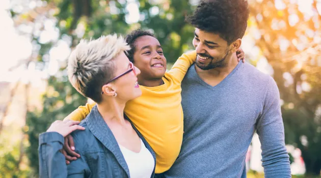 A young couple holding their daughter between them outdoors