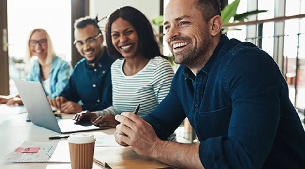 Four workers sitting and smiling at a table