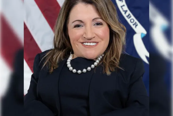 Professional headshot of Julie Hocker in front of the Labor Department flag