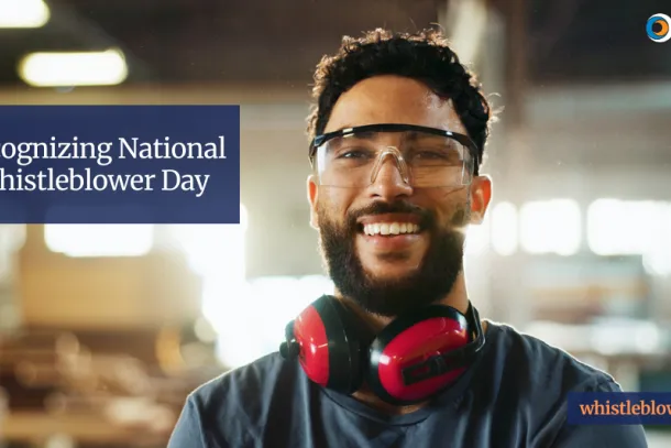 A male worker who is wearing safety glasses and ear protection stands in a warehouse. "Recognizing National Whistleblower Day. whistleblowers.gov"