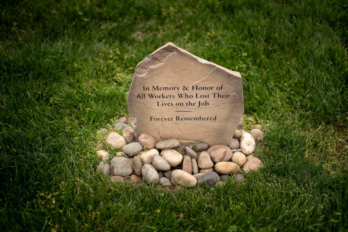 A memorial stone with an engraving that reads, “In memory and honor of all workers who lost their lives on the job.”