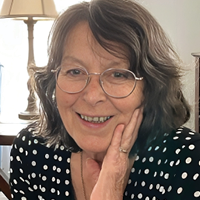 Headshot of Jeannie Ayer, smiling in a living room.
