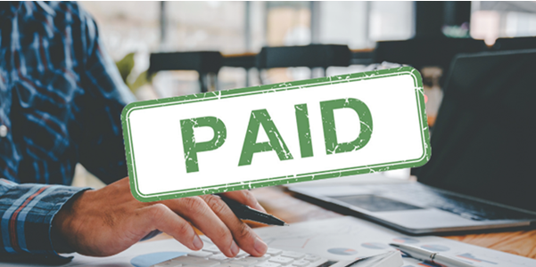 Someone working at a desk with the acronym PAID superimposed on top of the photo.