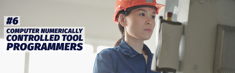 Woman wearing a hardhat stands at a computer-type device in an industrial environment. "Number six: Computer numerically controlled tool programmers"