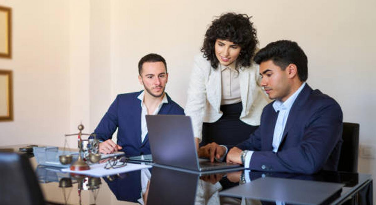 three people working on a laptop