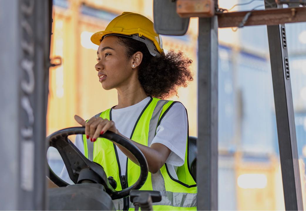 Woman wearing a yellow vest and construction helmet