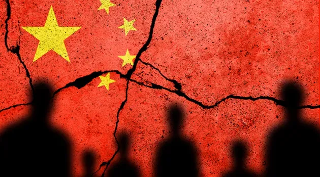 silhouettes of people against a cracked flag of china