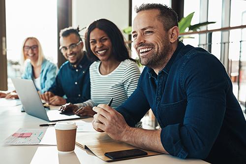 Four workers sitting and smiling at a table
