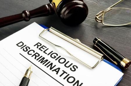 A clipboard with a piece of paper with the heading of "religious discrimination"