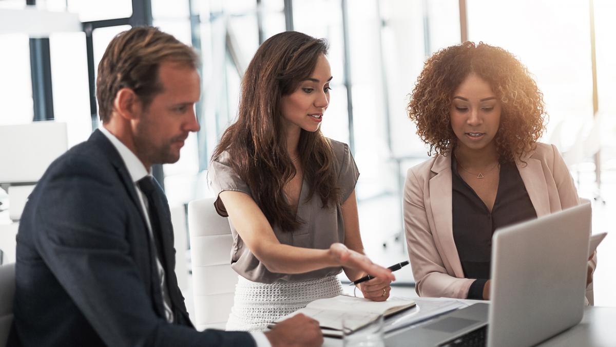 Cropped shot of a group of businesspeople using a laptop during a meeting in an office