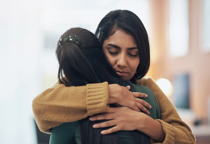 Two people hugging and consoling each other.
