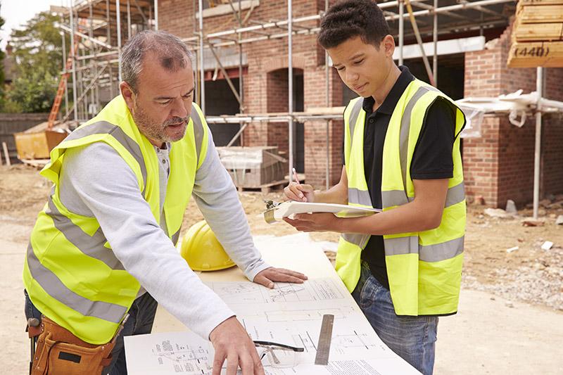 Teacher and student looking at blueprints